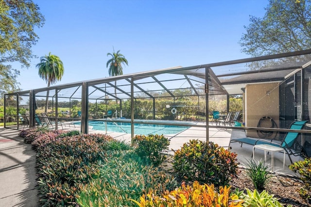 view of pool with a patio and glass enclosure