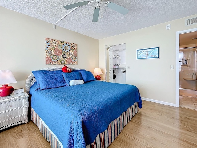 bedroom with hardwood / wood-style flooring, ceiling fan, and a textured ceiling