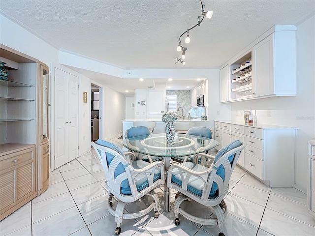 dining space featuring light tile patterned floors and a textured ceiling