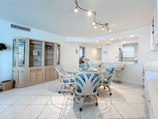 dining space with light tile patterned floors and a textured ceiling