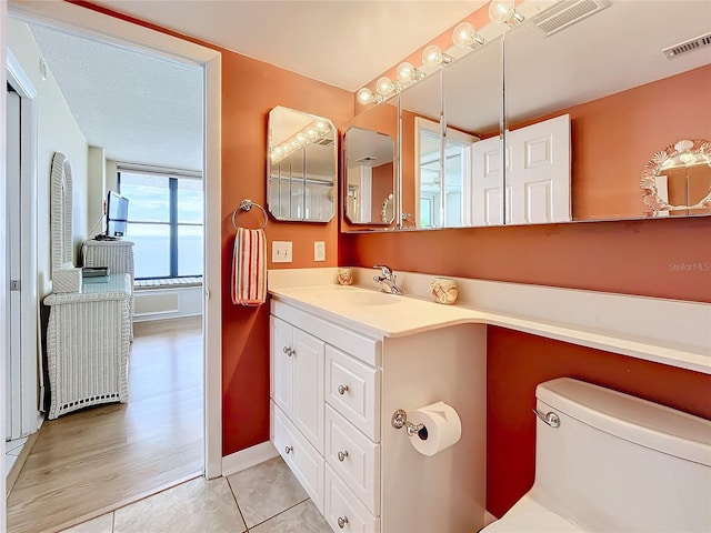 bathroom featuring vanity, tile patterned floors, and toilet