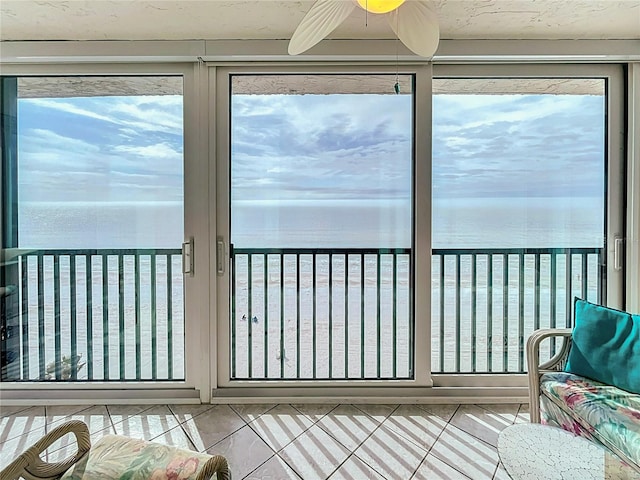 sunroom with a water view and ceiling fan