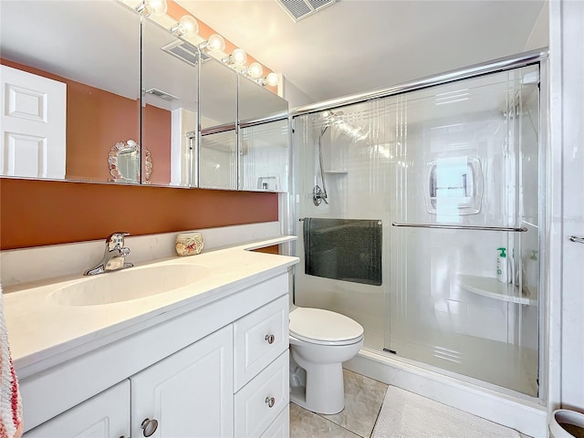 bathroom featuring a shower with door, vanity, tile patterned flooring, and toilet