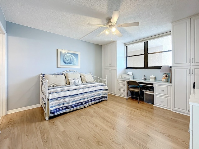 bedroom featuring ceiling fan, a textured ceiling, and light wood-type flooring