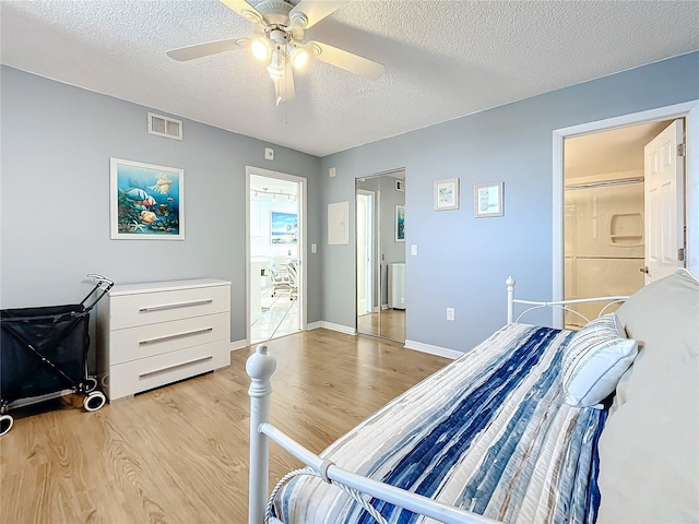 bedroom with ceiling fan, light hardwood / wood-style floors, and a textured ceiling