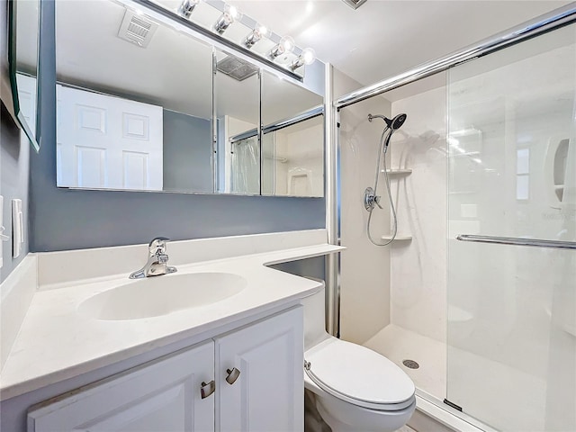 bathroom with a shower with door, vanity, and toilet