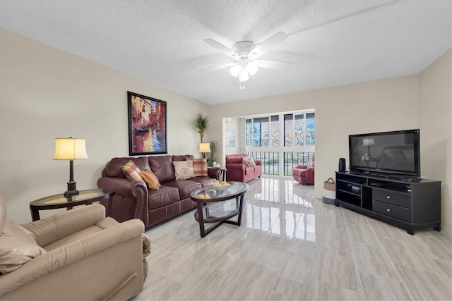 living room featuring ceiling fan and a textured ceiling