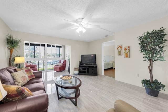 living room with a textured ceiling and ceiling fan