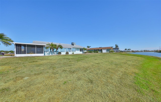 view of yard featuring a water view and a sunroom