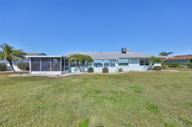 rear view of house with a yard and a sunroom