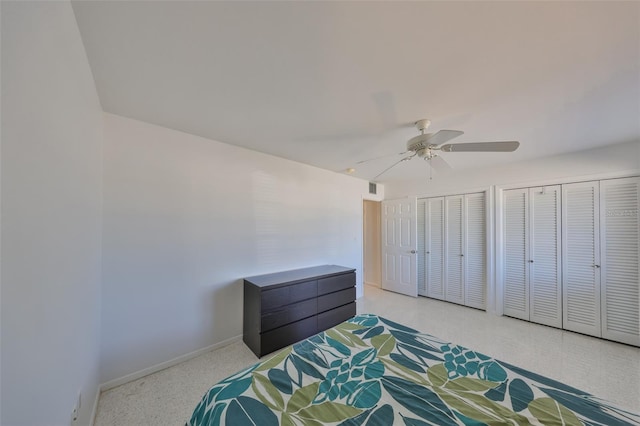 bedroom with ceiling fan and multiple closets