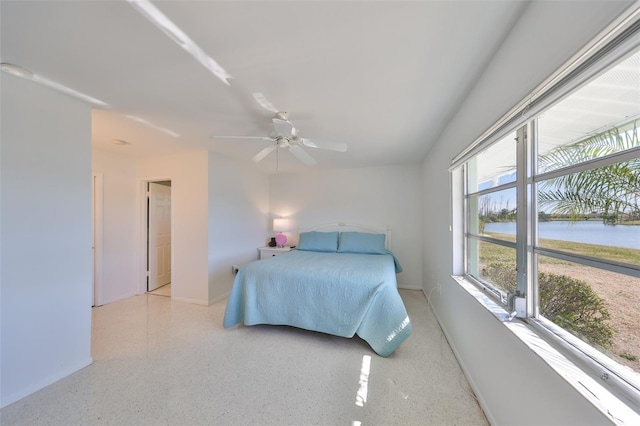 bedroom featuring a water view and ceiling fan