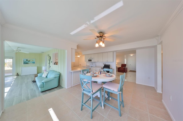 tiled dining room featuring ceiling fan and ornamental molding