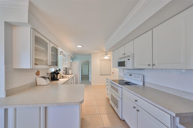 kitchen featuring white appliances, white cabinets, crown molding, and tasteful backsplash