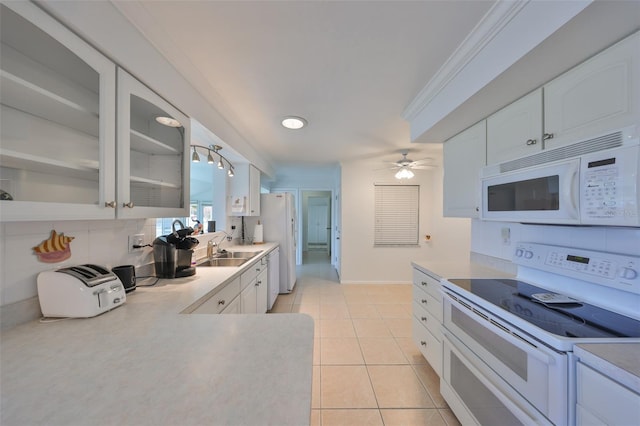 kitchen featuring white cabinetry, sink, white appliances, light tile patterned floors, and decorative backsplash