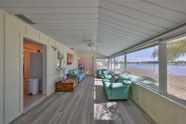 unfurnished sunroom featuring lofted ceiling, a water view, and ceiling fan