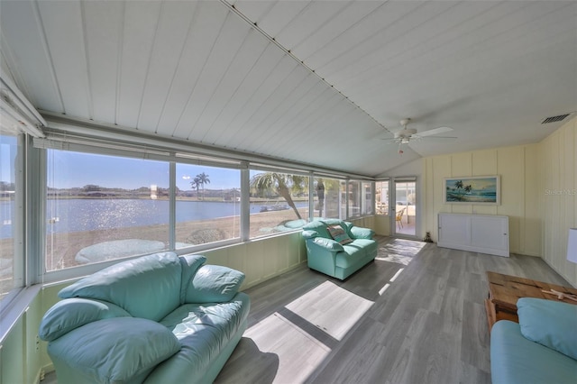 sunroom / solarium with ceiling fan, a water view, and vaulted ceiling