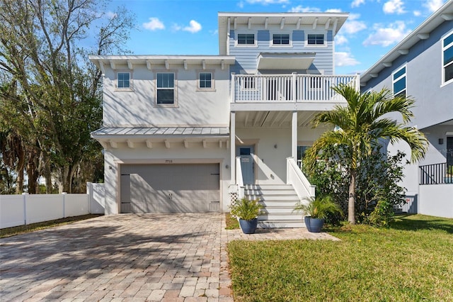 view of front of home with a balcony, a garage, and a front yard