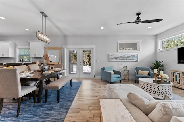 living room featuring sink, light hardwood / wood-style floors, french doors, and ceiling fan