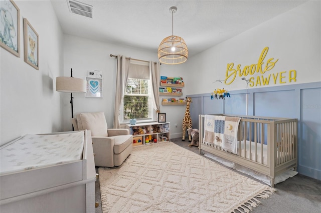 bedroom with a nursery area and carpet flooring