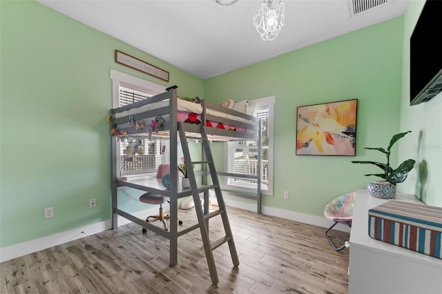 bedroom featuring light hardwood / wood-style floors and a notable chandelier