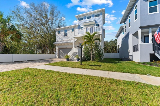 view of front facade with a garage, a front lawn, and a balcony