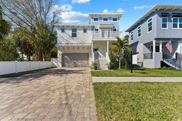 view of front of house with a garage, a balcony, and a front yard