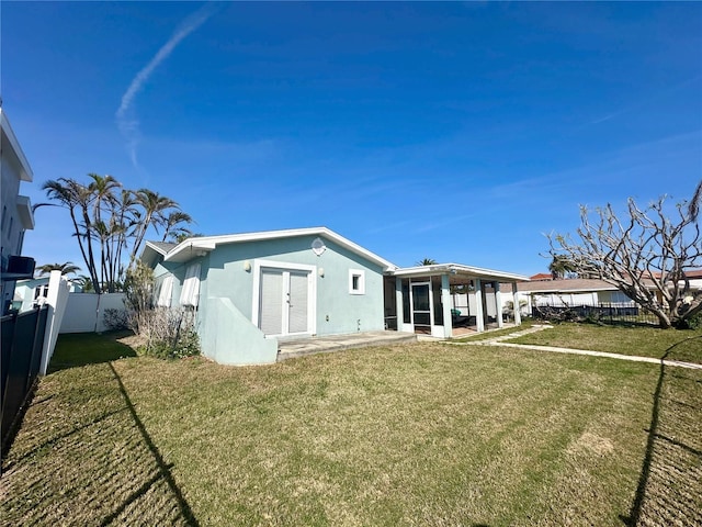 rear view of house featuring a patio area and a lawn