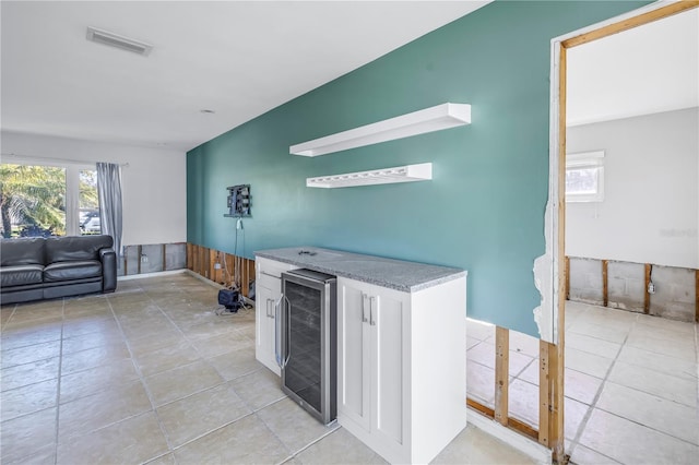 bar with beverage cooler and white cabinets