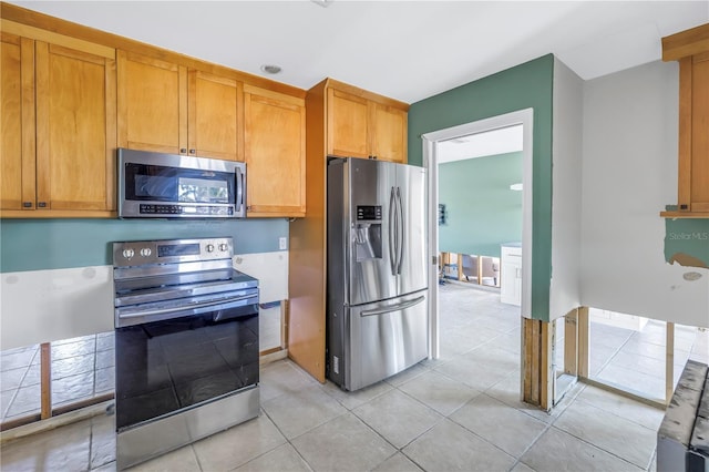 kitchen featuring light tile patterned floors and stainless steel appliances