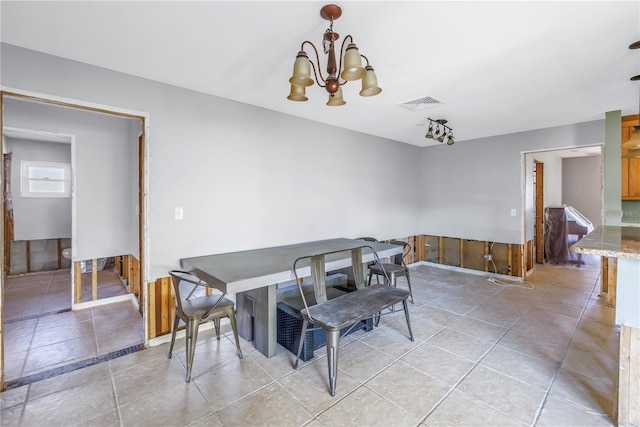 dining space with a chandelier and light tile patterned floors