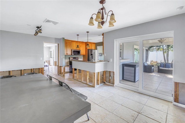 kitchen with pendant lighting, light tile patterned floors, an inviting chandelier, stainless steel appliances, and a kitchen bar