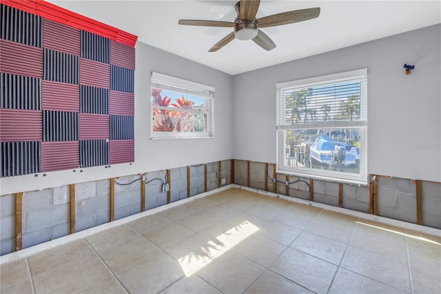 tiled empty room featuring ceiling fan