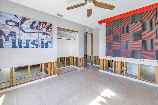 unfurnished bedroom featuring tile patterned flooring, two closets, and ceiling fan