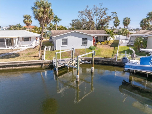 dock area featuring a lawn and a water view