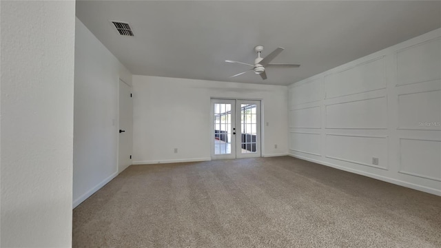 carpeted empty room with ceiling fan and french doors