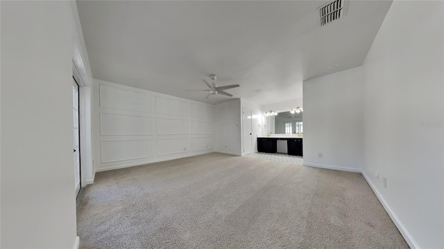 unfurnished living room featuring ceiling fan and light colored carpet