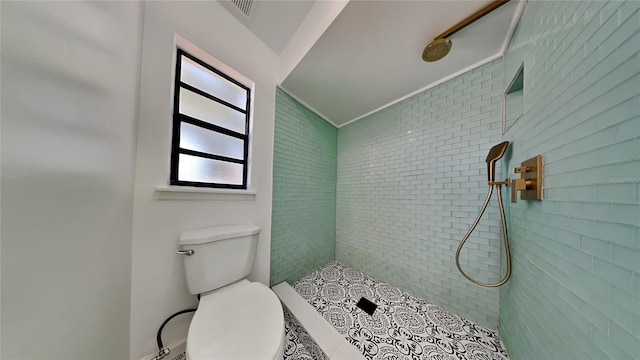 bathroom with toilet and tiled shower