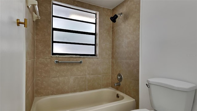 bathroom with tiled shower / bath combo and toilet