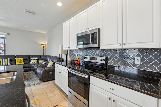 kitchen featuring white cabinetry, dark stone countertops, and appliances with stainless steel finishes