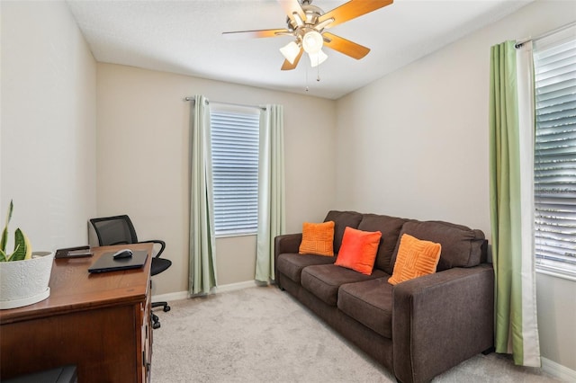 carpeted office space with ceiling fan