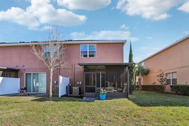 back of property featuring a sunroom, a yard, and cooling unit