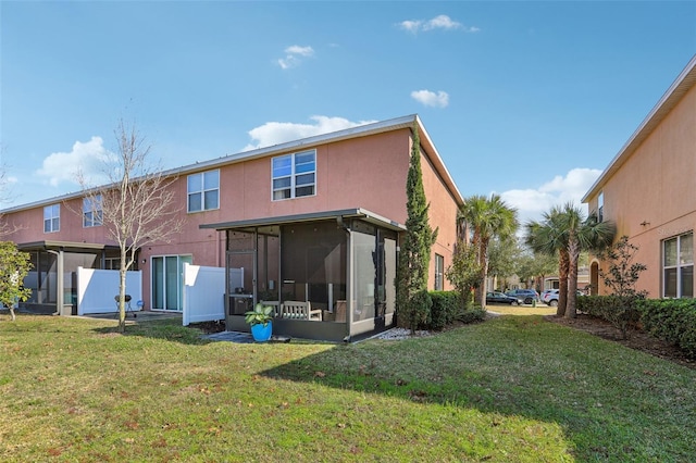 back of property featuring a sunroom and a lawn