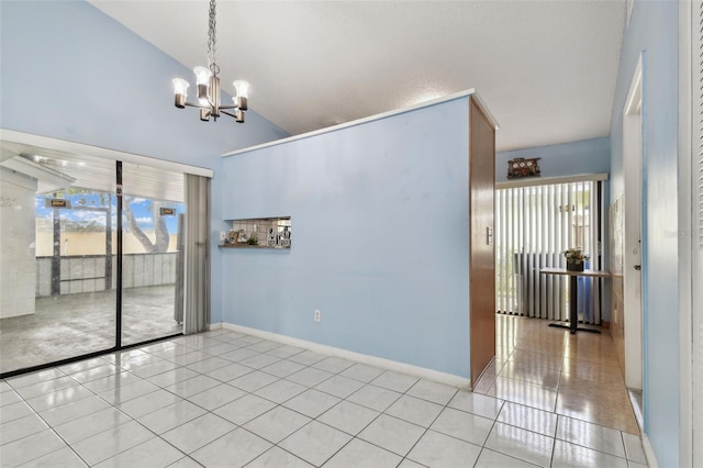 tiled spare room with a chandelier and high vaulted ceiling