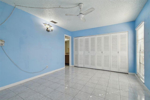 unfurnished bedroom with light tile patterned flooring, a closet, and a textured ceiling