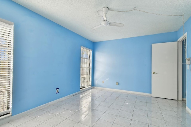 tiled empty room featuring a textured ceiling and ceiling fan