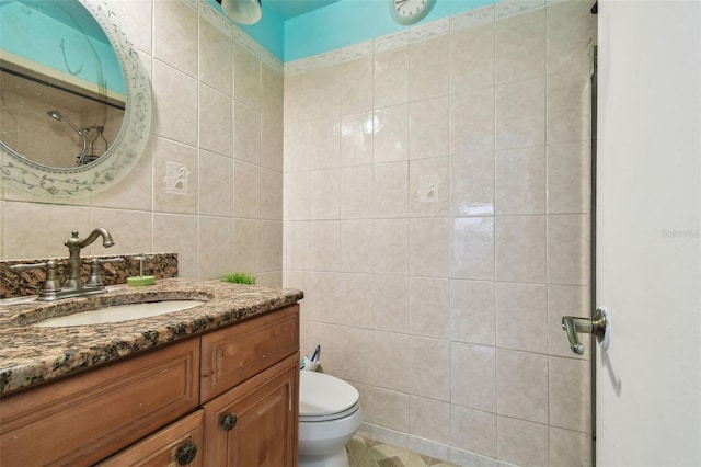 bathroom with vanity, toilet, and tile walls