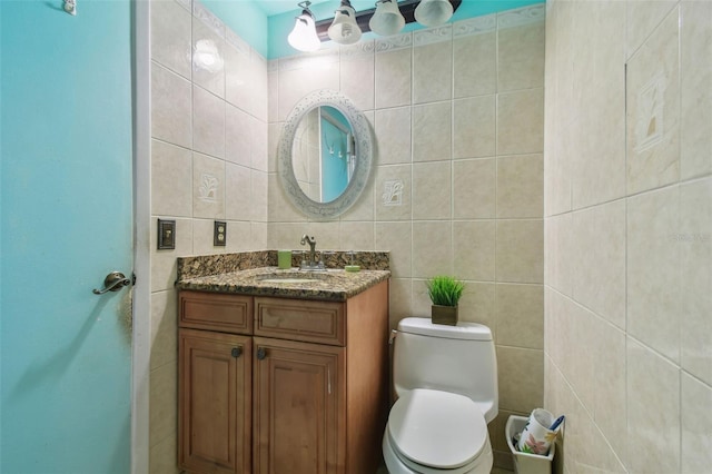 bathroom featuring vanity, toilet, and tile walls