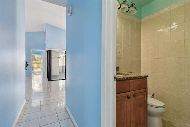 bathroom featuring vanity, tile walls, tile patterned floors, and toilet