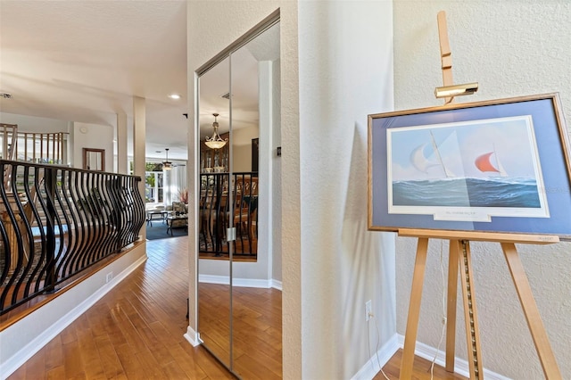 hallway with hardwood / wood-style flooring